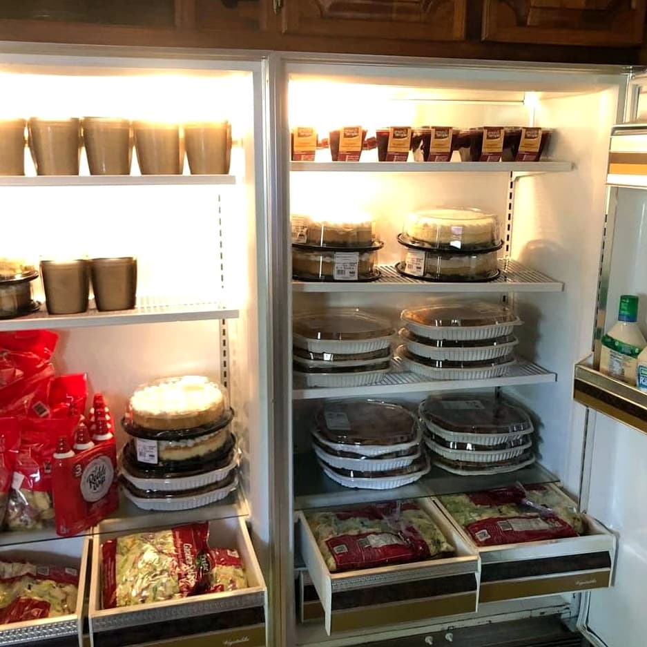 A refrigerator packed with donated pies, salads, and desserts for Kid Connection